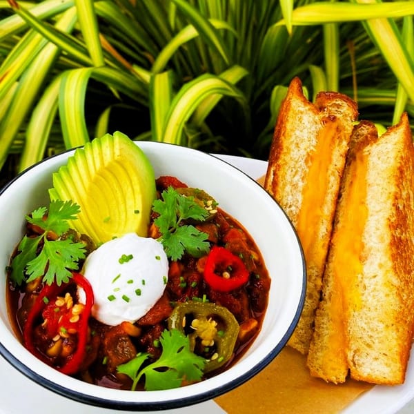 Vegan chili with avocado, sour cream, cilantro, and grilled cheese sandwiches from The Wild Chive.
